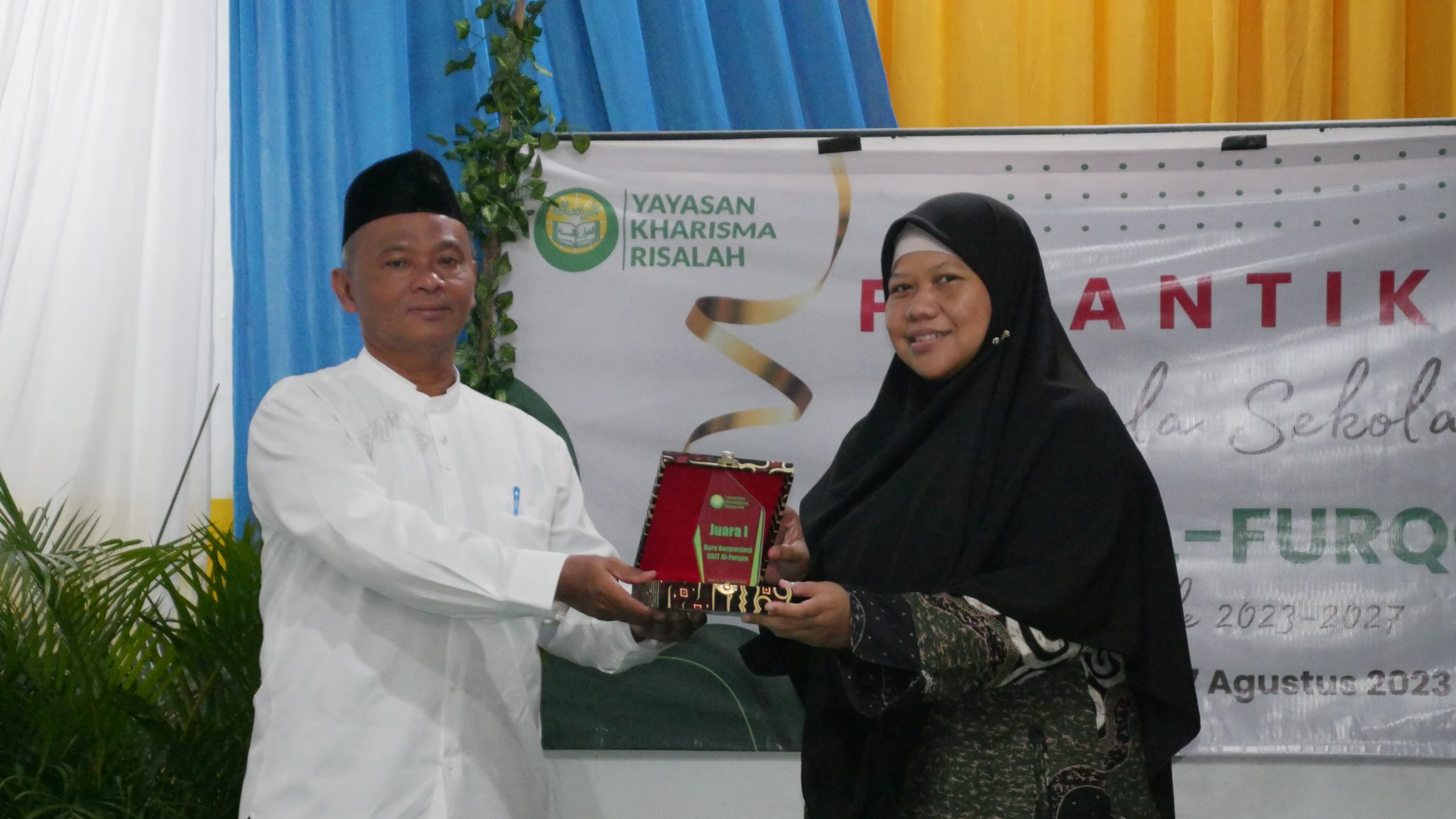 Pemberian plakat penghargaan guru favorit SDIT Al-Furqon diwakili Ketua Yayasan Kharisma Risalah kepada Ibu Tika Rusmayanti
